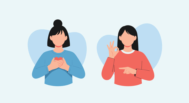 Two young women communicate using sign language where one places hands over a heart and the other makes an okay gesture with a smile.
