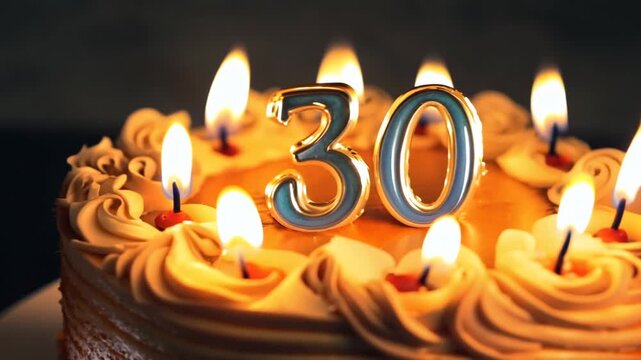 The video captures a festive 30th birthday cake glowing warmly in the dark. A large "30" candle sits amidst many small, flickering lit candles, emphasizing the celebration and milestone.