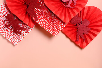 Red paper hearts with glitter cupids and patterns on pink background.