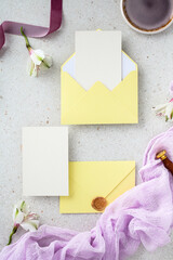 Top view of wedding stationery suite with yellow envelopes and blank invitation card.