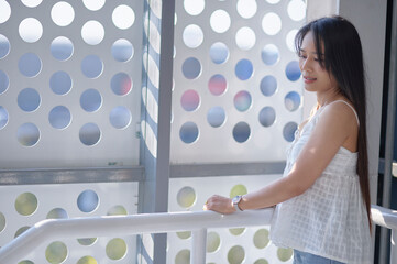 Young Woman Enjoying Natural Light in Modern Architectural Space
