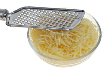 Ramequin de fromage r&acirc;p&eacute; avec une r&acirc;pe &agrave; fromage en gros plan sur fond blanc