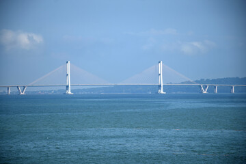 Obraz premium From a distance the landscape of the long Suramadu bridge connecting Java and Madura Island, the blue sky during the day