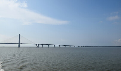 From a distance the landscape of the long Suramadu bridge connecting Java and Madura Island, the blue sky during the day