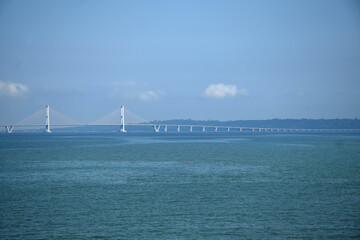 Obraz premium From a distance the landscape of the long Suramadu bridge connecting Java and Madura Island, the blue sky during the day