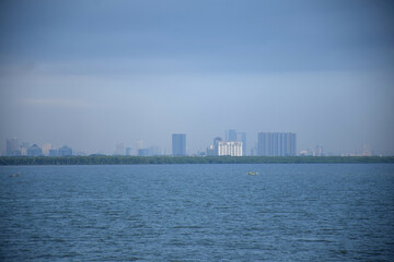 From a distance, the land stretches with the ever-growing number of high-rise buildings standing on the east coast of Surabaya, Indonesia.