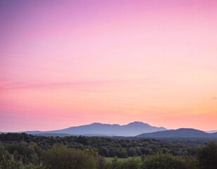Fototapeta premium Pastel Sunset Over Rolling Hills With Soft Pink and Purple Sky Over Quiet Countryside