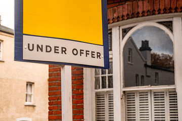 Fototapeta premium Under Offer Estate agency sign with space for copy – Bold Red Estate Agent Sign Symbolising Property Transaction Progress