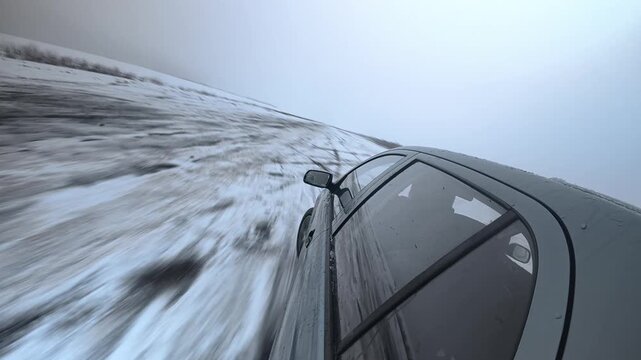 Winter car drifting filmed from diagonal body mounted camera