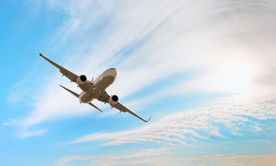 Obraz premium White passenger airplane flying in the sky amazing clouds in the background - Travel by air transport