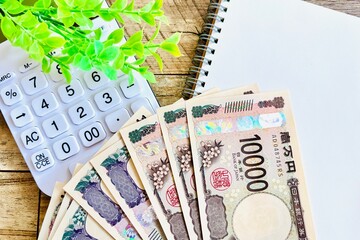 白い電卓と一万円とノート