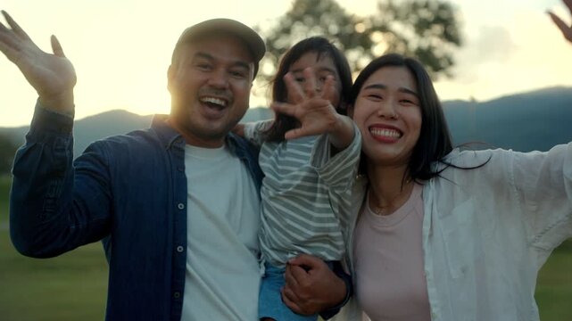 Parents and son wave their hands goodbye to the camera with warm smiles and joyful family moment strong bonding with quality time and childhood happiness, Father&rsquo;s Day celebration concept.
