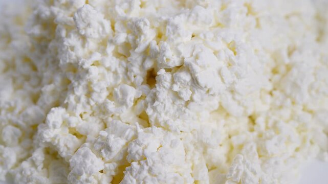 Closeup view of fresh dairy curds with subtle yellow highlights, Highresolution image capturing delicate texture of natural cottage cheese grains with moisture and yellow hints