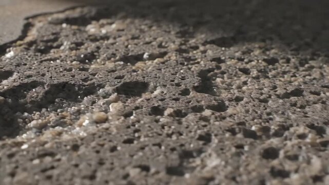 Extreme close up of very old damaged concrete showing weathered surface and exposed aggregate