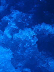 Obraz premium Close up of frozen water crystals with bright blue lighting. Winter background.