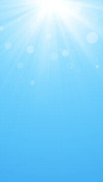 blue sky with top sun rays and shiny bokeh lights ,nature weather spring and summer day time vertical social media background