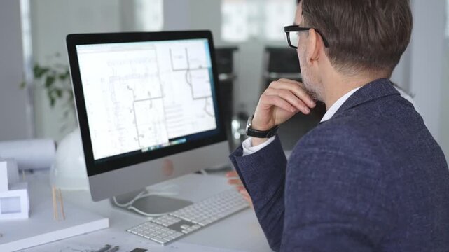 Architecture and engineering team collaborating on project blueprints using computer aided design software in an office. Business and architecture concept