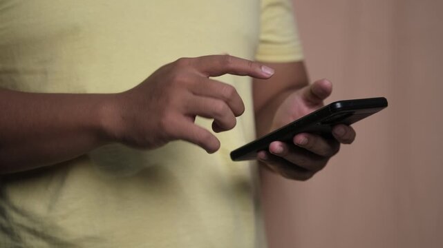 Close-up of a man clenching his fist while using a smartphone, expressing anger, stress, frustration, and emotional tension related to digital communication.