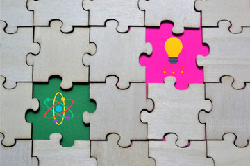 Obraz premium Wooden puzzle with missing pieces revealing atom and light bulb icons on colorful backgrounds symbolizing fusion of science, creativity, and innovative thinking for editorial and educational 