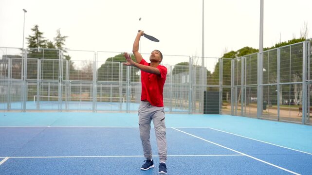 African american man playing pickleball and hitting the ball