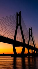 Obraz premium Silhouette of cable-stayed bridge at sunset.
