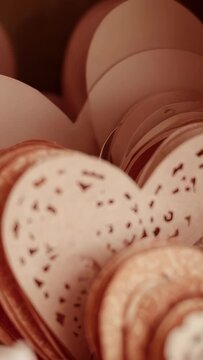 Vertical video: Moving camera showing front paper heart on craft desk, showcasing layered texture