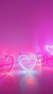 Vertical video: Power cords supplying current, neon hearts pulsing on studio floor for display