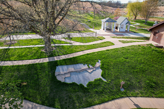Aerial view of a map of the United States embedded in vibrant green grass near a gazebo, Underwood, Iowa, United States.