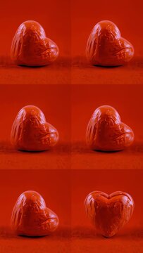 Vertical video: Shifting lights driving glossy heart changing pink to red on studio table 2x3 grid