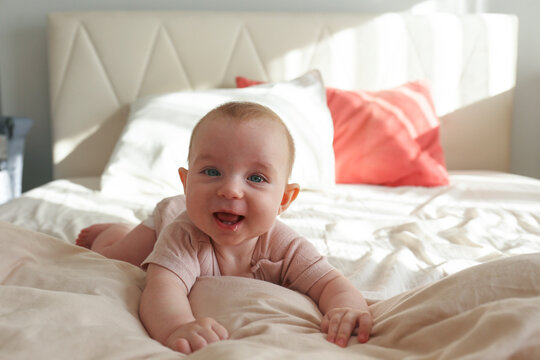 Playful baby on the bed. Copy space, background.