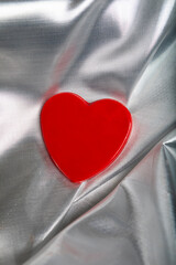 Red Chocolate Candy Heart on Silver Fabric Background