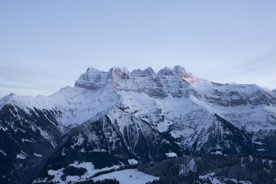 View of snow-capped mountains gleam in the soft, predawn light, a majestic winter wonderland under a serene sky, Morgins, Valais, Switzerland.