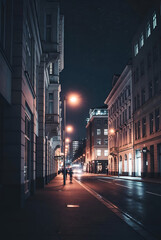 Fototapeta premium City street at night with illuminated buildings and streetlights