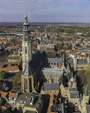 Aerial view of the Lange Jan tower piercing the skyline amidst the old town's red-tiled roofs and charming canals, Middelburg, Zeeland, Netherlands.