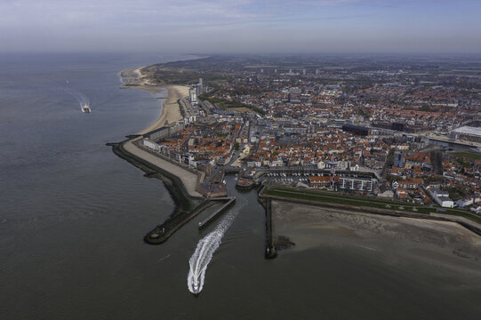 Aerial view of the waterway cutting through the city meeting the sea, boats sailing on the water contrasting with the urban landscape, Vlissingen, Zeeland, Netherlands.
