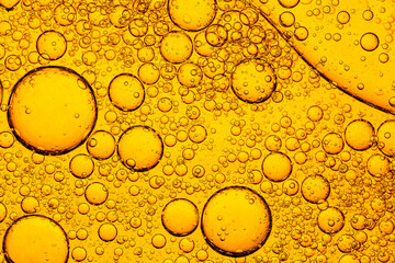 Golden Oil Bubbles in Water Macro Abstract Background,A detailed macro shot of golden oil droplets of various sizes floating in water, creating a beautiful abstract pattern with liquid texture. © banjongseal324