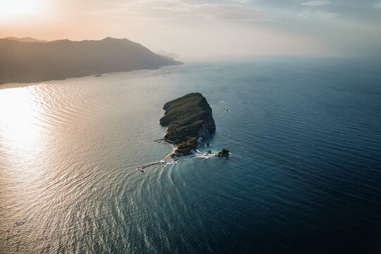 Aerial view of Sveti Nikola Island basks in the sunlight, contrasting with the deep blue Adriatic Sea, Budva, Budva Municipality, Montenegro.