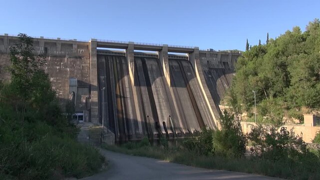 Dam concrete reservoir lake pine trees Sant Ponc afternoon sunlight sky