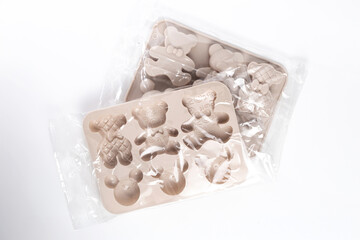 Two silicone baking molds in packaging on white background at angle