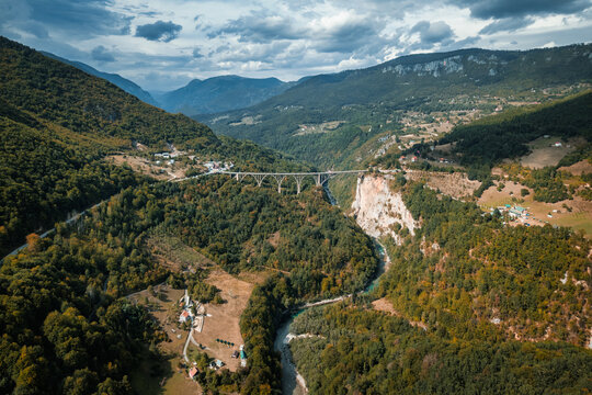 Aerial view of the majestic Durdevica Tara Bridge gracefully arches over the vibrant Tara River amidst Montenegro's dramatic mountainous landscape, Zabljak, Opstina Pljevlja, Montenegro.
