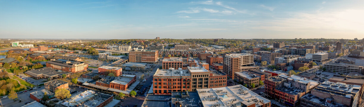 Aerial view of the city reveals a mix of brick buildings and modern structures under a soft sky, Omaha, Nebraska, United States.