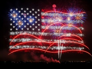Vibrant red, white, and blue fireworks creating a flag-like spectacle in the dark night sky, symbolizing national festivity