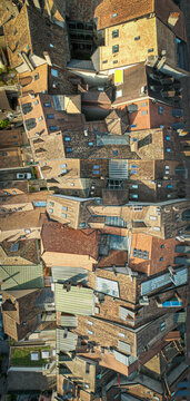 Aerial view of rooftops, a patchwork of weathered tiles and sun-kissed walls creating a maze of textures and tones, Morges, Vaud, Switzerland.