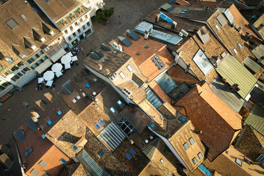 Aerial view of tightly packed buildings showcasing varied roof colors and textures, a maze of architectural charm from above, Morges, Vaud, Switzerland.