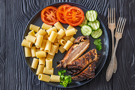 roasted pork ribs with pasta and fresh vegetables