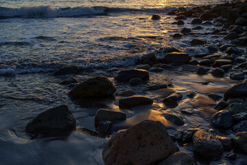 Waves Washing Over Coastal Rocks in Soft Sunset Light