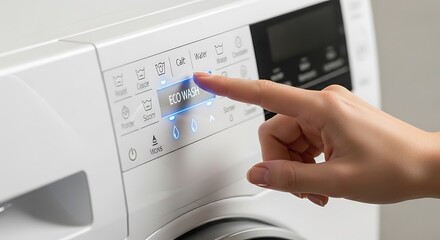 Finger presses ECOWASH button on modern washing machine control panel pressing