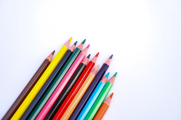 Naklejka premium A collection of colored pencils arranged diagonally against a white background