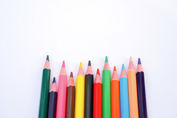 A vibrant collection of colored pencils arranged in a playful arc across a clean white background