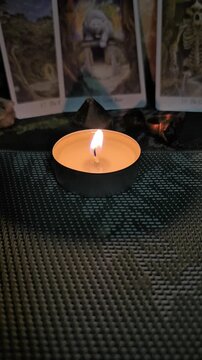 Burning Candle and Tarot Cards in Mystical Atmosphere